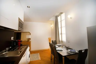 a kitchen with a table with chairs and a sink at Princess Victoria Standing Presta in Cannes
