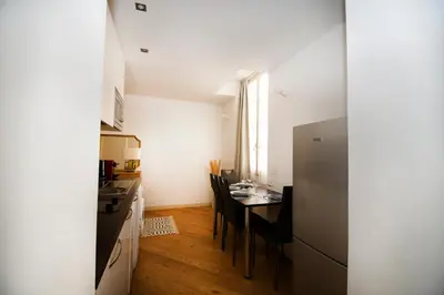 a small kitchen with a table and a refrigerator at Princess Victoria Standing Presta in Cannes
