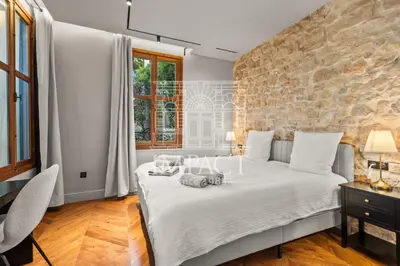 a bedroom with a white bed with a stone wall at Cannes Villa - 2167 - Impact Center in Cannes