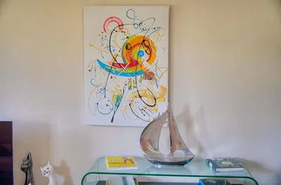 a vase on a table with a painting on the wall at Lumineux 3 chambres TERRASSE PISCINE PARKING A3B134 in Cannes