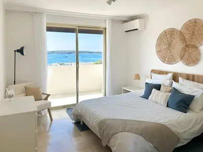a bedroom with a bed with a view of the ocean at Vue mer - Pointe Croisette - 1 chambre Spacieuse in Cannes