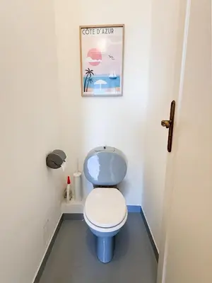 a bathroom with a toilet with a picture on the wall at Vue mer - Pointe Croisette - 1 chambre Spacieuse in Cannes
