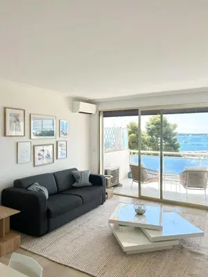 a living room with a couch and a glass table at Vue mer - Pointe Croisette - 1 chambre Spacieuse in Cannes