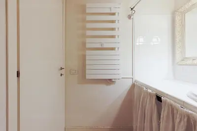 a bathroom with a glass door and a sink at CG Armenonville White in Cannes