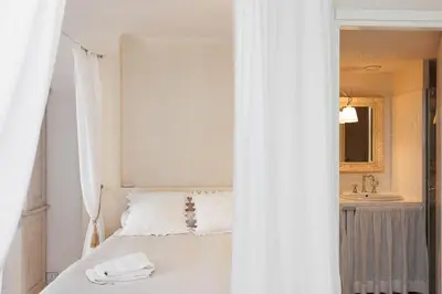 a white bedroom with a bed and a sink at CG Armenonville White in Cannes