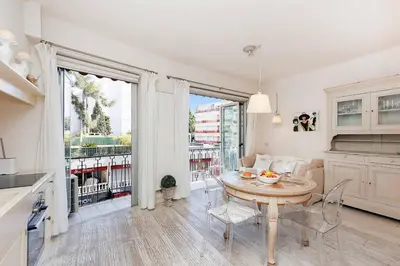 a kitchen and dining room with a table and chairs at CG Armenonville White in Cannes