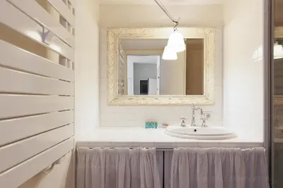 a bathroom with a sink and a mirror at CG Armenonville White in Cannes