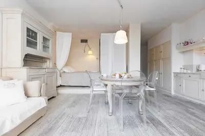 a kitchen and dining room with a table and chairs at CG Armenonville White in Cannes