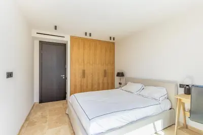 a bedroom with a white bed and a wooden door at Villa Cannes superbe vue mer in Cannes