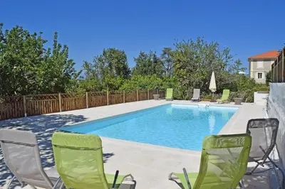 a swimming pool with two lawn chairs and a table and chairsktop at Villa Super Cannes avec vue mer in Vallauris
