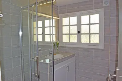 a bathroom with a sink and a glass shower at Villa Super Cannes avec vue mer in Vallauris