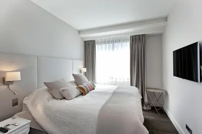 a white bedroom with a large bed and a window at REF 1238 - Cannes Croisette - Sea view apartment for rent in Cannes