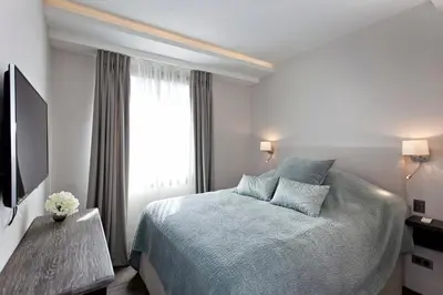 a white bedroom with a bed and a window at REF 1238 - Cannes Croisette - Sea view apartment for rent in Cannes