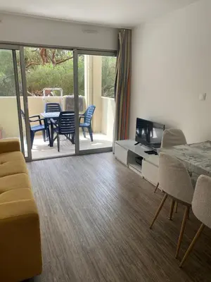 a living room with a couch and a table and chairs at Apparemment proche de la mer in Cannes