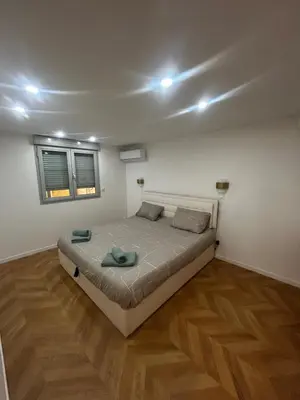 a bedroom with a bed in a room with wooden floors at La pause cannoise RDC in Cannes