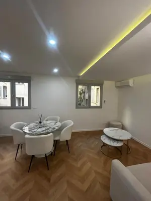 a living room with a table and white chairs at Escapade Cannoise in Cannes