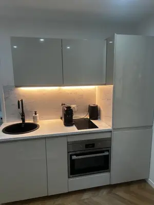 a kitchen with white cabinets and a sink and a stove at Escapade Cannoise in Cannes
