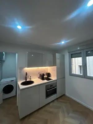 a white kitchen with a sink and a dishwasher at Escapade Cannoise in Cannes