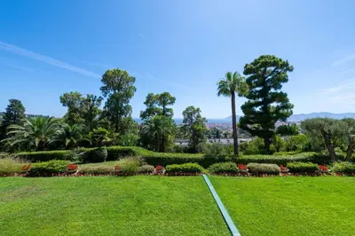a park with a palm tree and a green lawn at Spacious 1-Br with Sea View Residence with Pool Cannes in Cannes