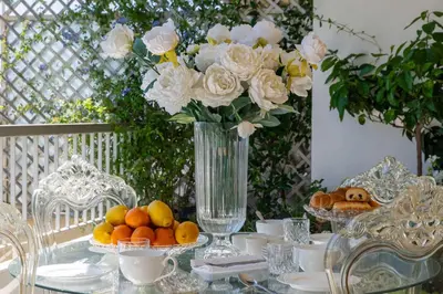 a glass table with a vase of flowers and fruit at Spacious 1-Br with Sea View Residence with Pool Cannes in Cannes