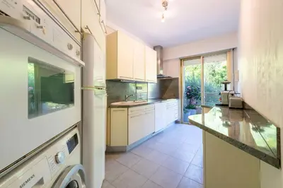 a kitchen with white cabinets and a large window at Spacious 1-Br with Sea View Residence with Pool Cannes in Cannes