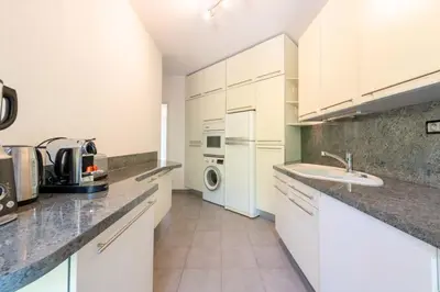 a kitchen with white cabinets and a washer and dryer at Spacious 1-Br with Sea View Residence with Pool Cannes in Cannes