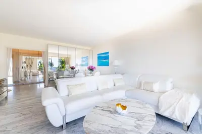 a white living room with a white couch and a table at Spacious 1-Br with Sea View Residence with Pool Cannes in Cannes