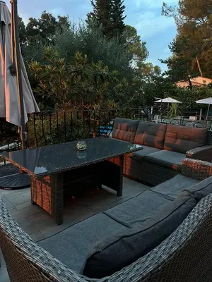 a hammock with a table and a couch at Cocon in Le Cannet