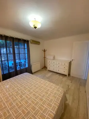 a bedroom with a bed and a dresser and a window at Cocon in Le Cannet