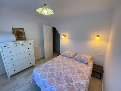 a bedroom with a bed and a dresser in it at Cocon in Le Cannet