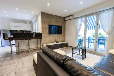 a living room with a couch and a kitchen at Family Flat Cannes Centre in Cannes