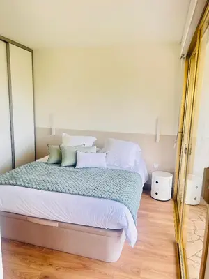 a bedroom with a bed with white sheets and pillows at Cannes Croix des Gardes in Cannes