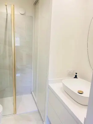 a white bathroom with a shower and a sink at Cannes Croix des Gardes in Cannes
