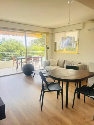 a living room with a table and a couch at Cannes Croix des Gardes in Cannes