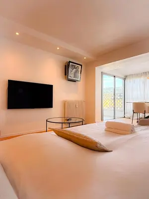 a bedroom with a large bed with a flat screen tv on the wall at Le Noé By ApiRent #Climatisation #Wifi #Balcon in Cannes
