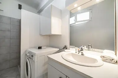 a bathroom with a sink and a washing machine at LE BRISTOL avec balcon au calme en centre-ville in Cannes