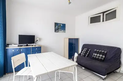 a living room with a white table and a couch at LE BRISTOL avec balcon au calme en centre-ville in Cannes