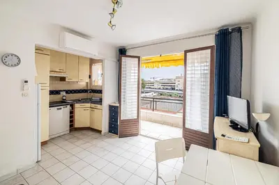 a kitchen and living room with a view of a city at LE BRISTOL avec balcon au calme en centre-ville in Cannes