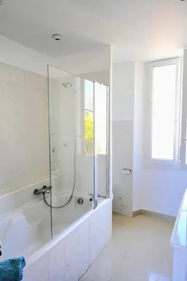 a white bathroom with a shower and a tub at Villa de la Roche - Spacieux appartement bourgeois in Cannes