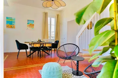a dining room with a table and chairs in a room at Villa de la Roche - Spacieux appartement bourgeois in Cannes