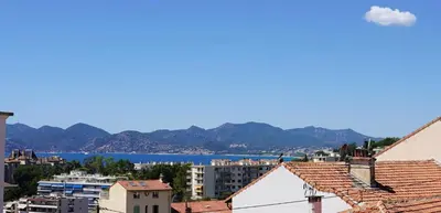 a view of a city with mountains and a body of water at Villa de la Roche - Spacieux appartement bourgeois in Cannes