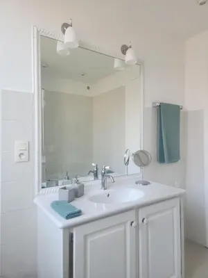 a bathroom with a sink and a large mirror at Villa de la Roche - Spacieux appartement bourgeois in Cannes