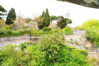 an old stone wall with trees and bushes at Seaview with Terrace in Cannes in Cannes