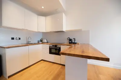 a kitchen with white cabinets and a wooden counter top at Seaview with Terrace in Cannes in Cannes