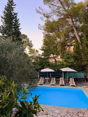 a swimming pool with chairs and umbrellas next to at Maison provençale in Le Cannet