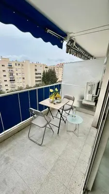 a patio with a table and chairs on a balcony at Nid douillet près de la Croisette in Cannes