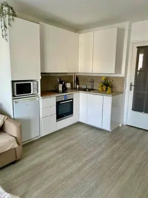 a white kitchen with white cabinets and appliances at Nid douillet près de la Croisette in Cannes