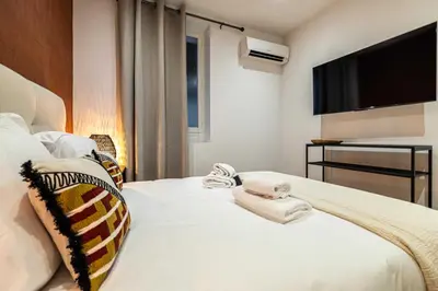 a bedroom with a white bed with a flat screen tv at Magnificent apartment - AC- 2BR- 4P - Cannes in Cannes