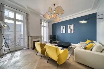 a living room with a couch and yellow chairs at REF 1412 - Cannes Center - Apartment for rent in Cannes