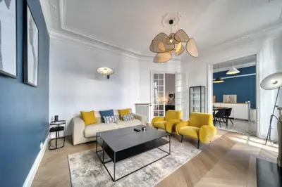 a living room with a couch and yellow chairs at REF 1412 - Cannes Center - Apartment for rent in Cannes